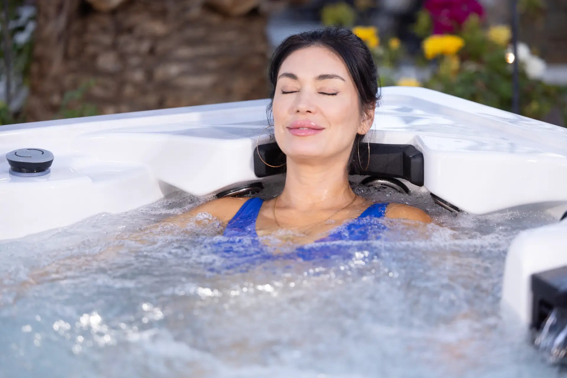 Woman relaxing in Nevis Luxury Hot Tub by Artesian Spas, showcasing hydrotherapy experience with soothing water jets, ideal for six-person capacity, featured by Creative Hot Tub Designs in Reno NV and Sparks NV.